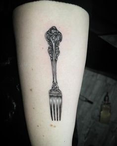 a black and white photo of a fork tattoo