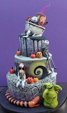 a three tiered cake decorated with halloween decorations and characters on it's sides