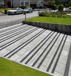 a parking lot with some cars parked in the background and grass growing on the ground