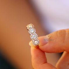 a close up of a person holding a ring with three diamonds on it's side