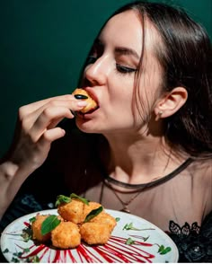 a woman eating food on top of a white plate