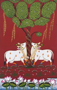 two cows standing next to each other in front of a tree with lots of flowers