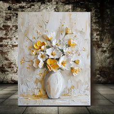 a white vase filled with yellow and white flowers on top of a tile floor next to a brick wall