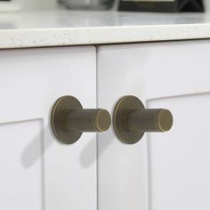 two knobs that are on the side of a cabinet