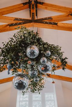 a chandelier hanging from the ceiling in a room with wooden beams and windows