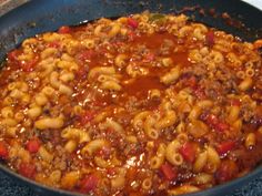 a skillet filled with macaroni and cheese on top of a stove