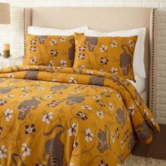 a bed with yellow and brown comforters in a bedroom