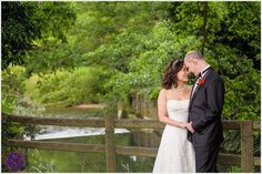 a bride and groom standing next to each other on a bridge