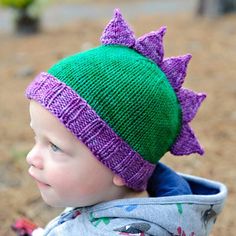 a small child wearing a purple and green hat with stars on it's head