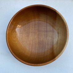 a wooden bowl sitting on top of a white table