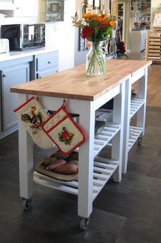 a kitchen island with flowers in a vase on top and stockings hanging from the legs