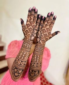 a woman's hands with henna tattoos on them