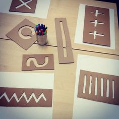 paper cut out shapes and pencils on a table