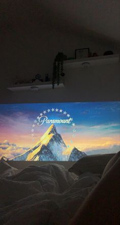 there is a large screen on the wall in the room that shows mountains and stars