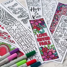 four coloring books with markers and pens sitting on top of each bookmarks are decorated with flowers, hearts, and the words love never fail