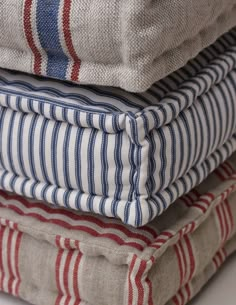 three folded pillows stacked on top of each other with red, white and blue stripes