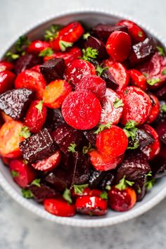 a bowl filled with beets and carrots on top of a table