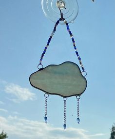 a wind chime hanging from the side of a tree with beads on it's strings