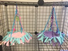 two cages with blue, pink and purple items hanging from the sides in front of each other