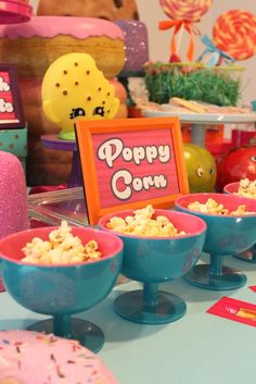 there are many bowls with popcorn in them on the table next to other items and decorations