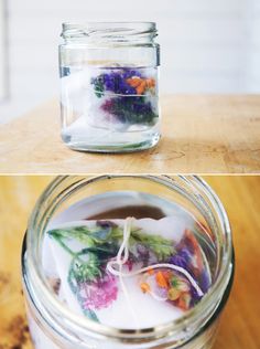 two jars filled with flowers sitting on top of a wooden table next to each other