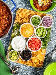 several bowls of chili, cheese and tortilla chips