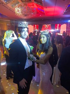 a man and woman in formal wear standing next to each other on a dance floor