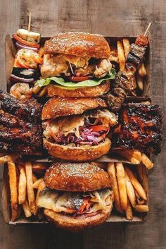 a box filled with lots of different types of food on top of each other next to french fries