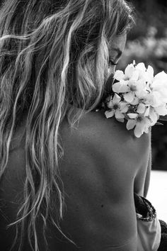 a woman with long hair holding flowers in her hand