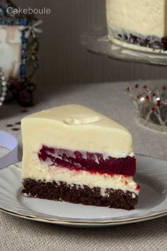 a piece of cake with white frosting and red toppings on a plate next to another slice