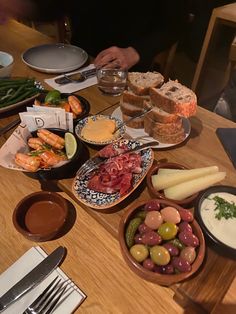 a wooden table topped with plates and bowls filled with food