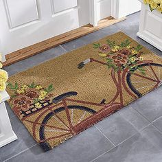 a door mat with a bicycle and flowers on it