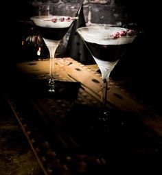 two martini glasses sitting on top of a table