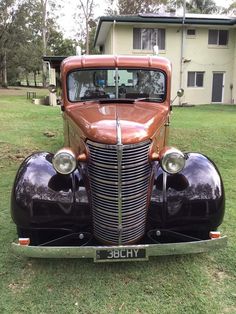 an antique car parked in front of a house