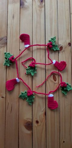 a crocheted christmas decoration with red and green decorations hanging from it's sides