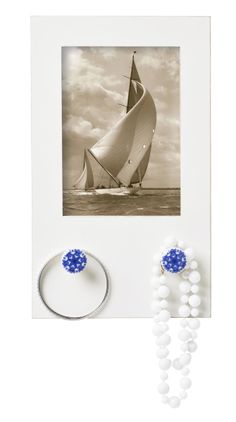 a sailboat on the water with beads around it and a ring in front of it