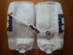 two cakes made to look like baseball gloves with happy birthday written on them, sitting on a table