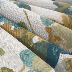 an upholstered fabric with flowers and leaves in blue, green, yellow and white colors