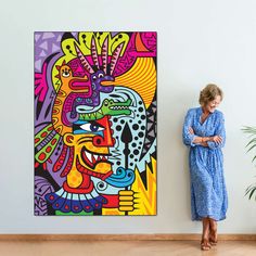 a woman standing in front of a painting on the wall next to a plant and potted plant