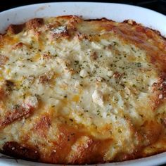 a casserole dish with cheese and herbs in it