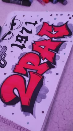 a notebook with graffiti writing on it and markers around the pages that read, draw