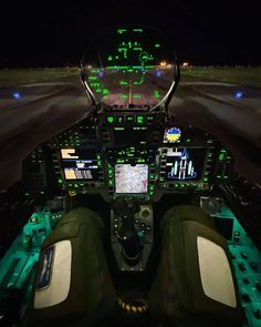 the cockpit of an airplane at night with green and white lights on it's windows