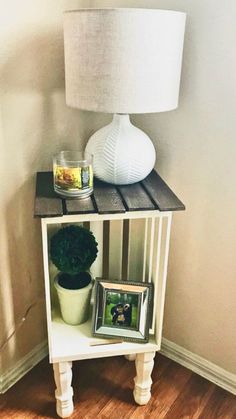 a small table with a lamp and pictures on it