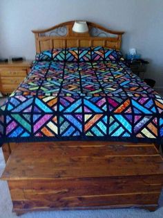 a bed with a colorful quilt on top of it