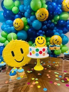 a table topped with a cake and lots of balloons