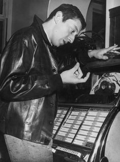 a man standing next to an old typewriter