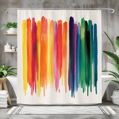 a colorful shower curtain with watercolor paint streaks in rainbow colors on the outside and inside