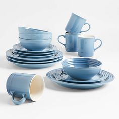 blue dishes and cups are stacked on top of each other