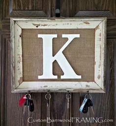 the letter k is hung on a wall with keys in it and hanging from hooks