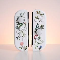 two white switch plates with flowers painted on them, one is facing the opposite direction